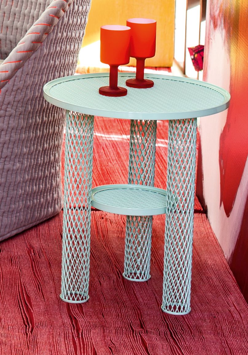 Net Beistelltisch von Moroso, klein, hellblau, mit Flechtmuster und zwei roten Deko-Gläsern.