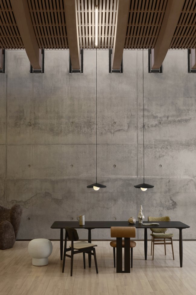 Esszimmer mit Esstisch und verschiedenen Stühlen, darunter ein NORR11 Elephant Dining Chair mit Frontpolsterung.