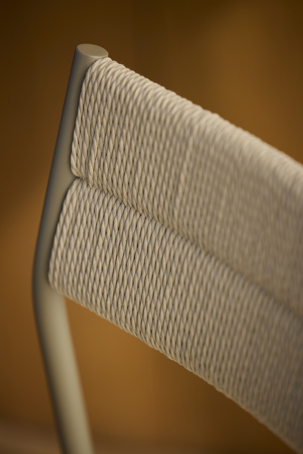 Detailaufnahme des Vev Dining Chair Stuhls Northern mit geflochtener Rückenlehne und grauem Gestell.
