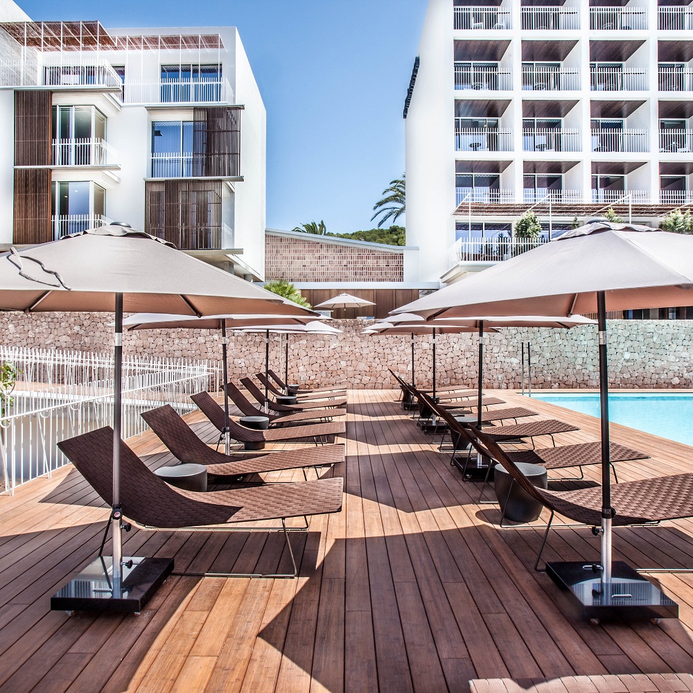Andreu World Trenza Liegen am Pool mit Sonnenschirmen auf einer Holzterrasse, Luxus Outdoor Möbel.