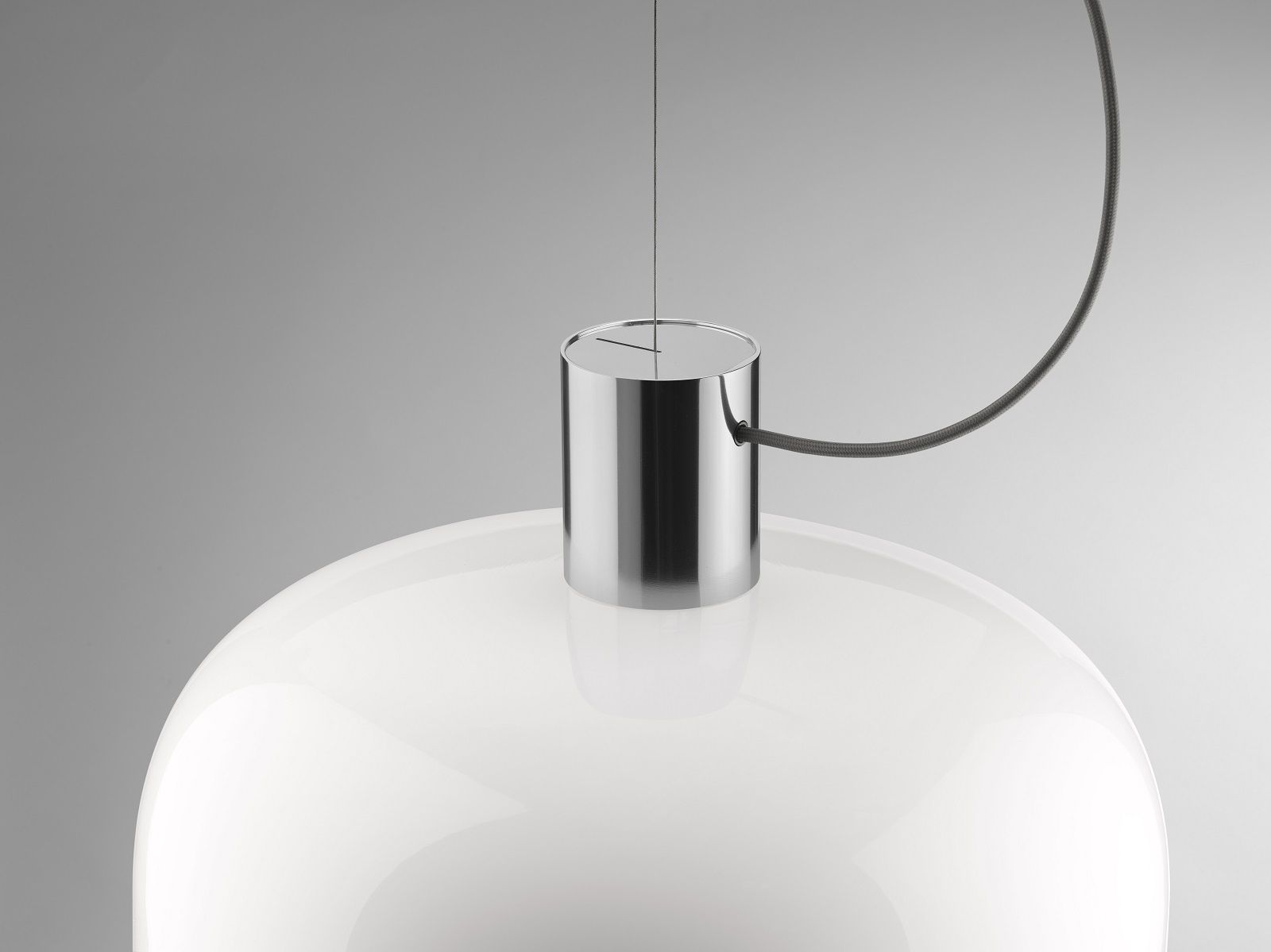 Detailaufnahme der Bellhop Pendelleuchte von Flos mit weißem Glasschirm und Chrom-Aufhängung.