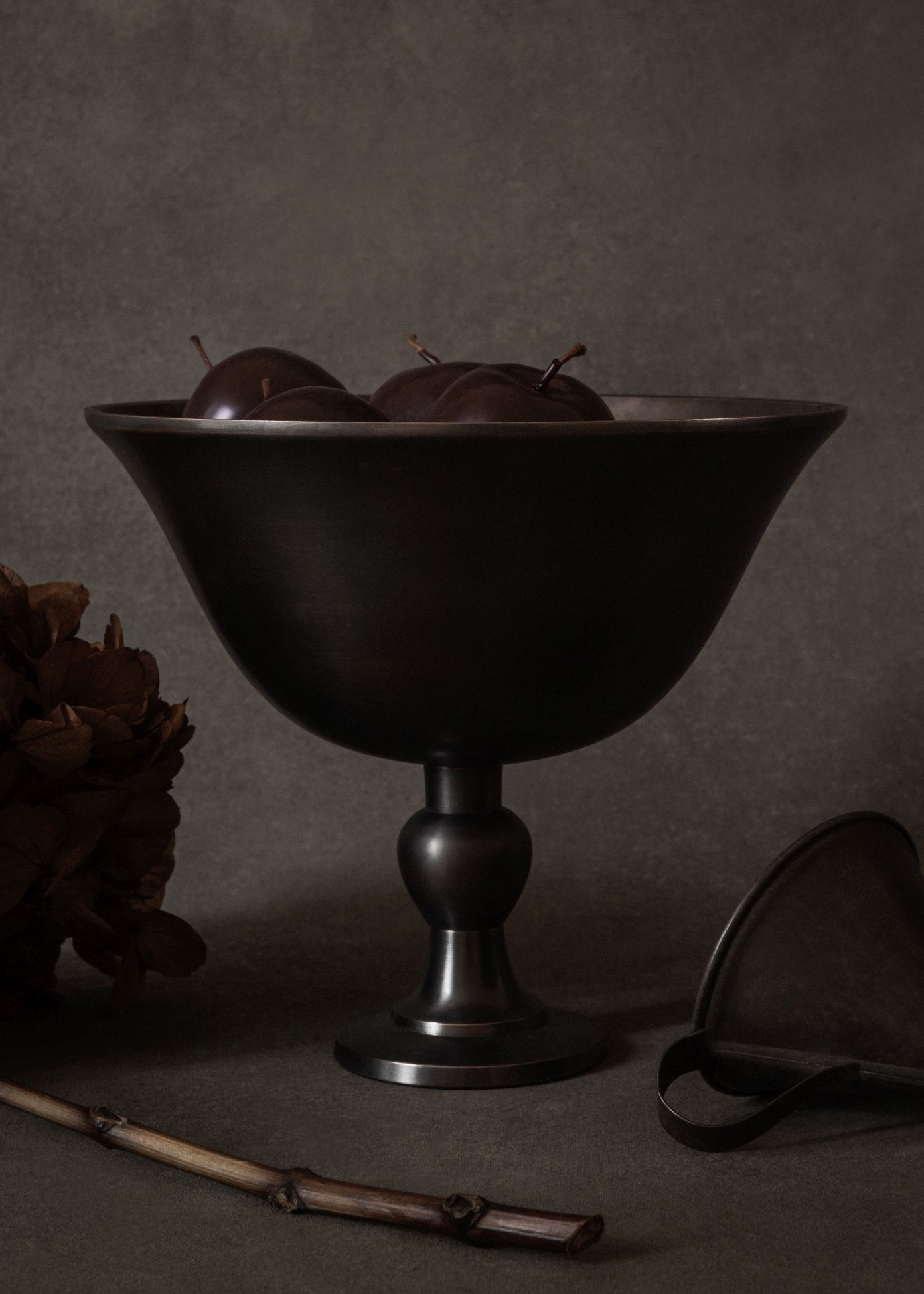 Elegante Audo Copenhagen Schale, Pavot Schale, aus dunklem Metall mit Pflaumen gefüllt, Tischdekoration.