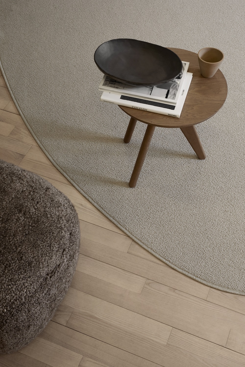 Norr11 Fin Side Table Beistelltisch aus Eichenholz mit Deko-Objekten auf beigem Teppich und Holzboden.