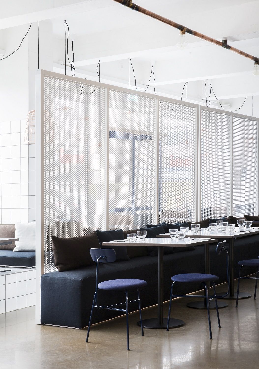 Afteroom Dining Chair von Audo Copenhagen in einem modernen Restaurant mit Sitzbänken und Tischen.