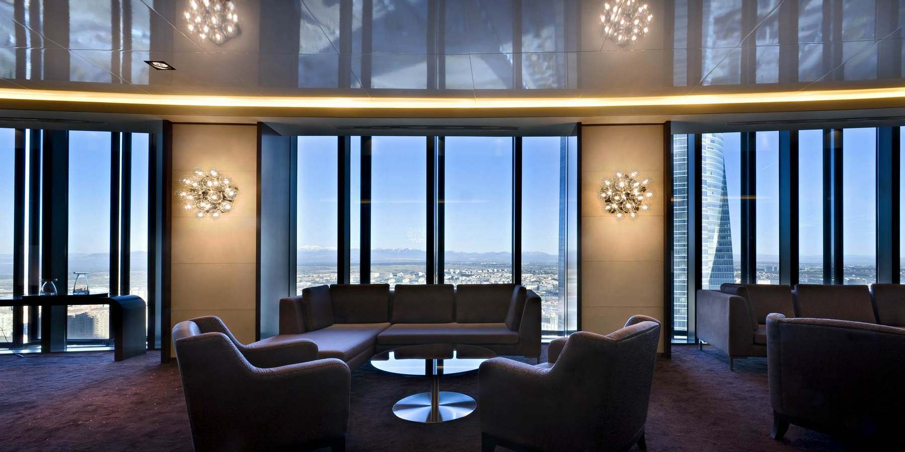 Taraxacum Wandleuchte von Flos in modernem Wohnzimmer mit Panoramafenster und Stadtblick. Design Lampe für stilvolle Innenarchitektur.