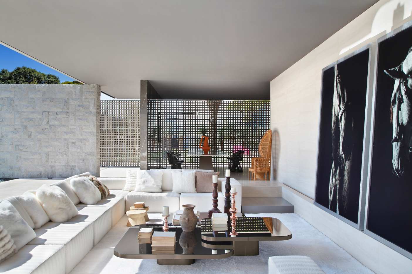 Heller Wohnraum mit ClassiCon Bow Coffee Table Couchtisch, weißem Sofa, Kissen und Pferde-Wandbildern.