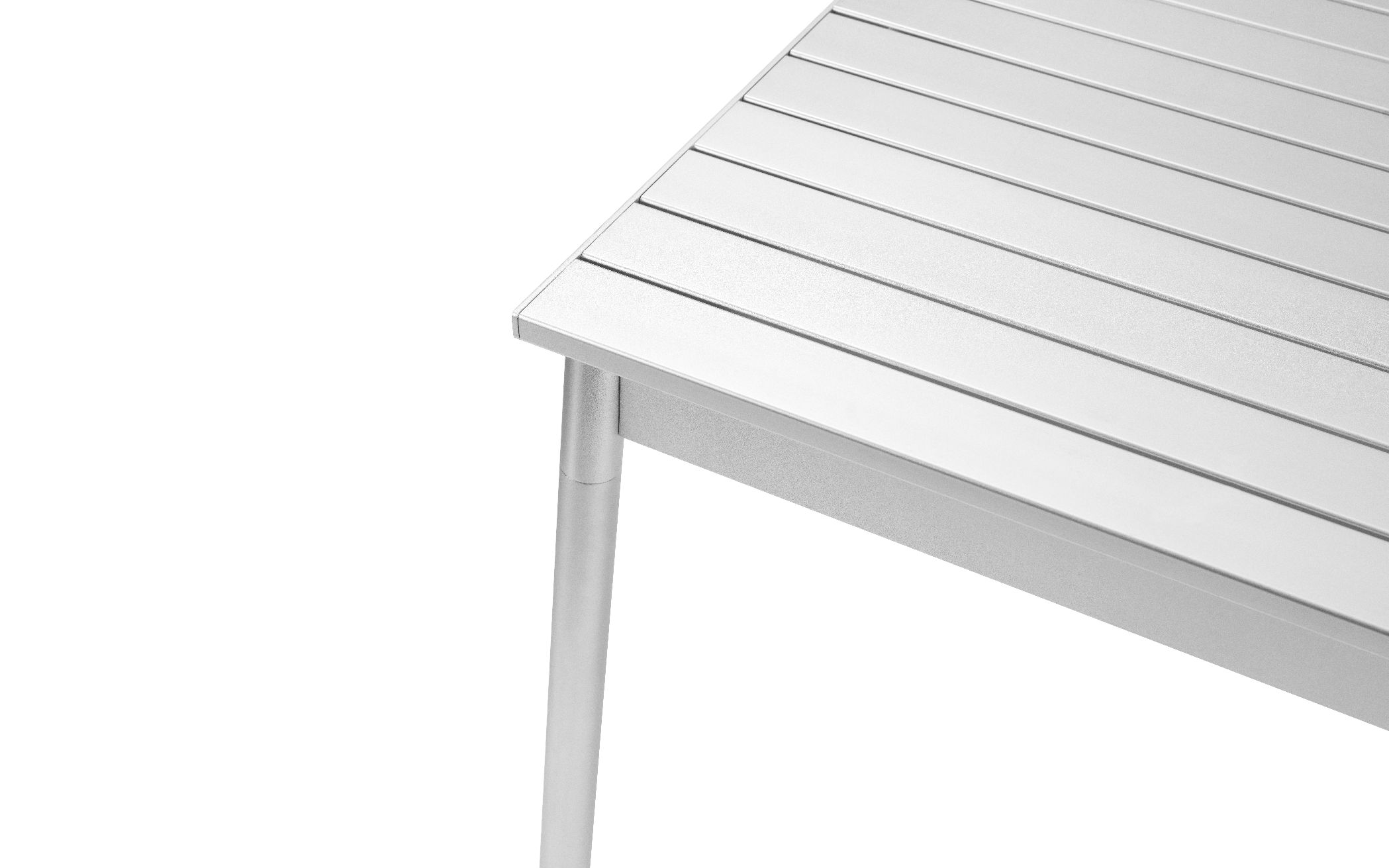 Detailaufnahme des Normann Copenhagen Ex Outdoor Tischs mit silberner Aluminium-Tischplatte und Tischbein.