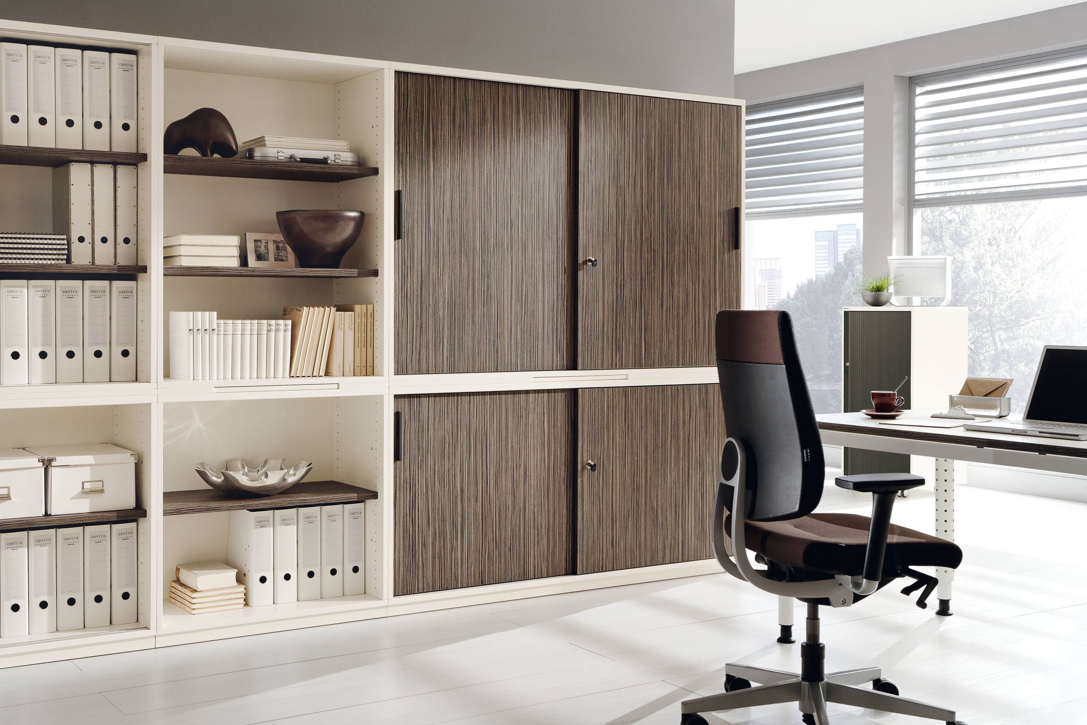 Büro mit Palmberg Schiebetürenschrank, Modell Prisma 2, mit Regalen und Büromöbeln.