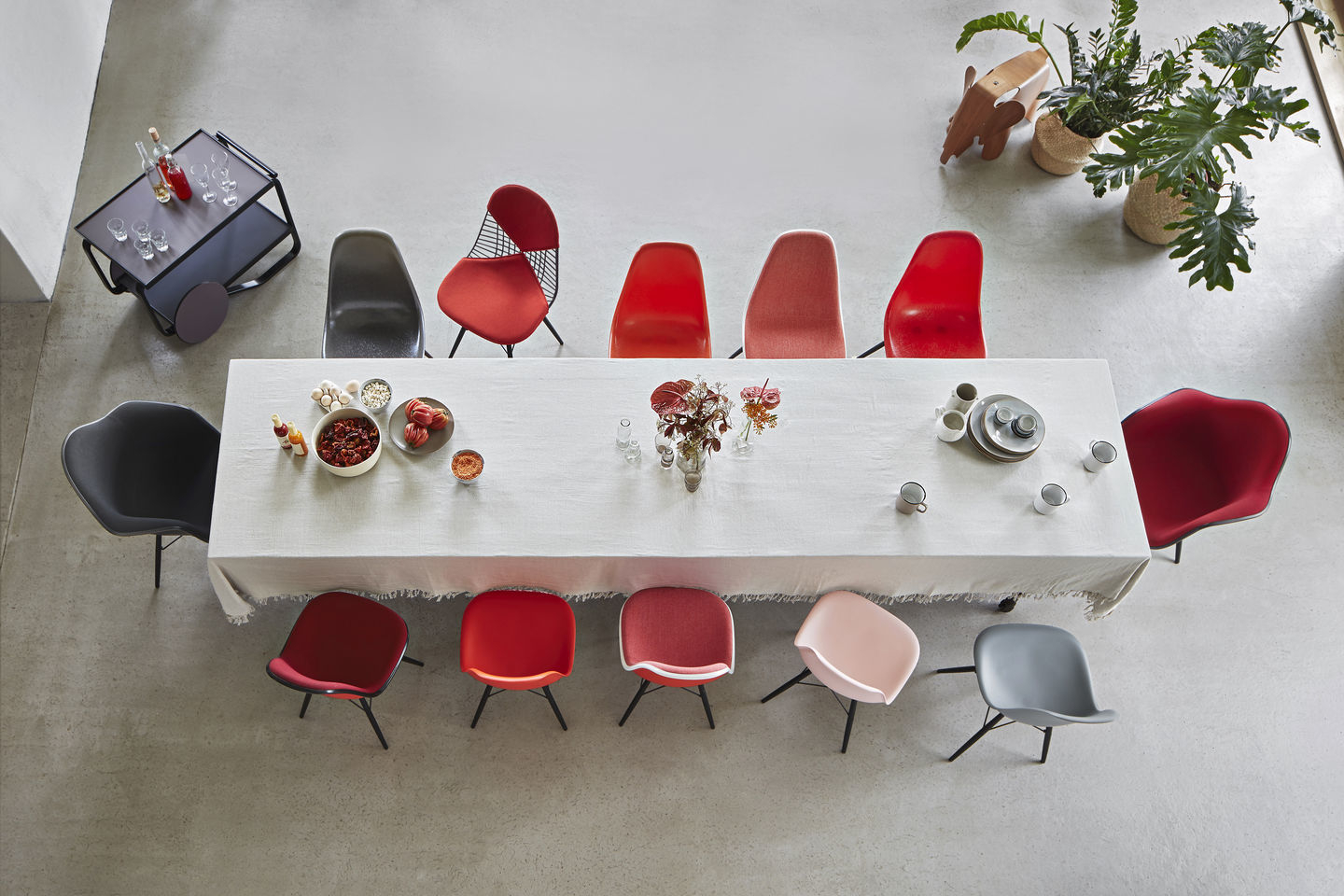 Esstisch mit verschiedenen Eames Plastic Arm Chairs, darunter ein DAR Stuhl Vitra in Kieselstein.