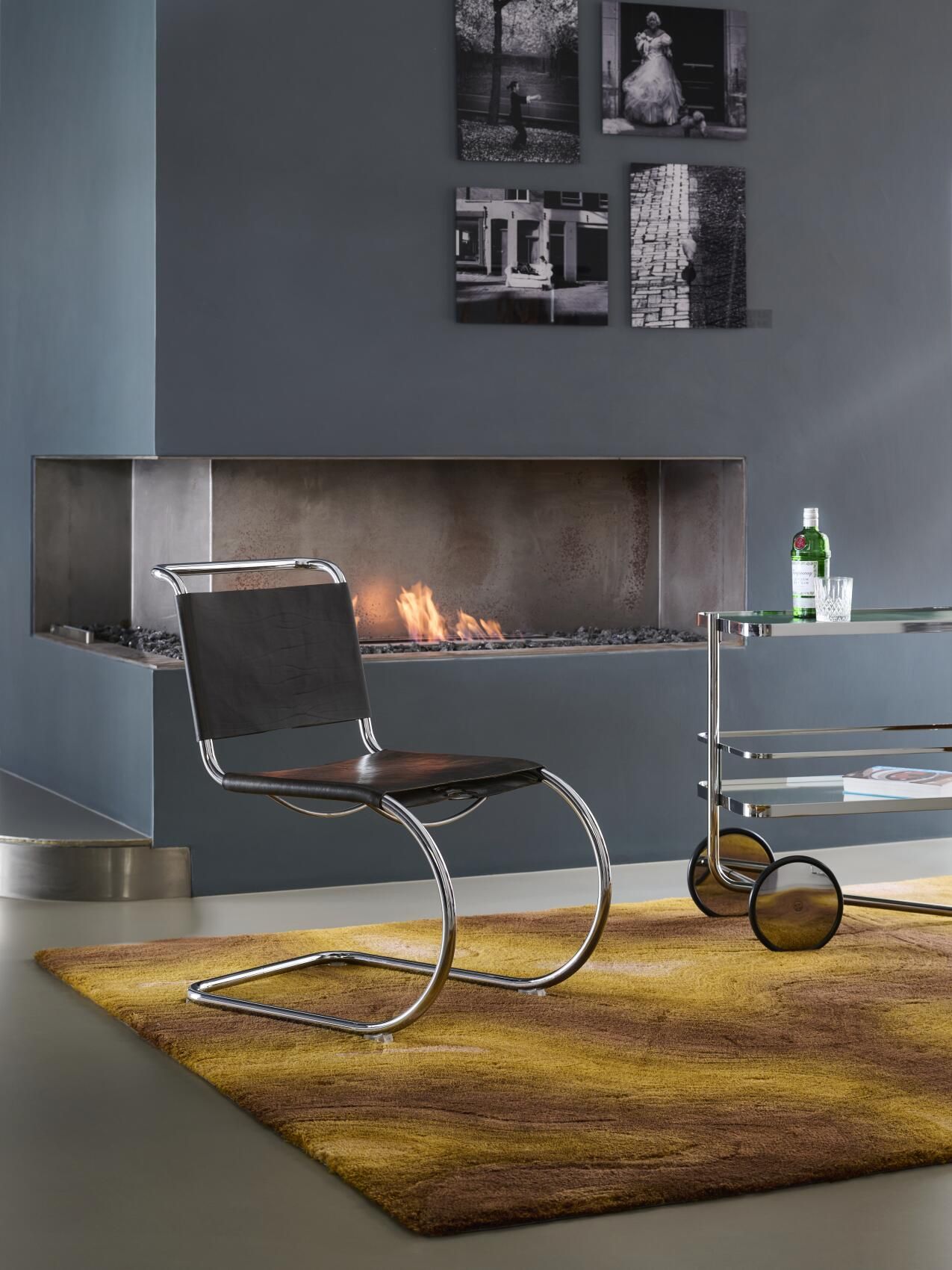 S 179 Thonet Barwagen aus Chrom und Glas im Interieur mit Kamin und Sessel.