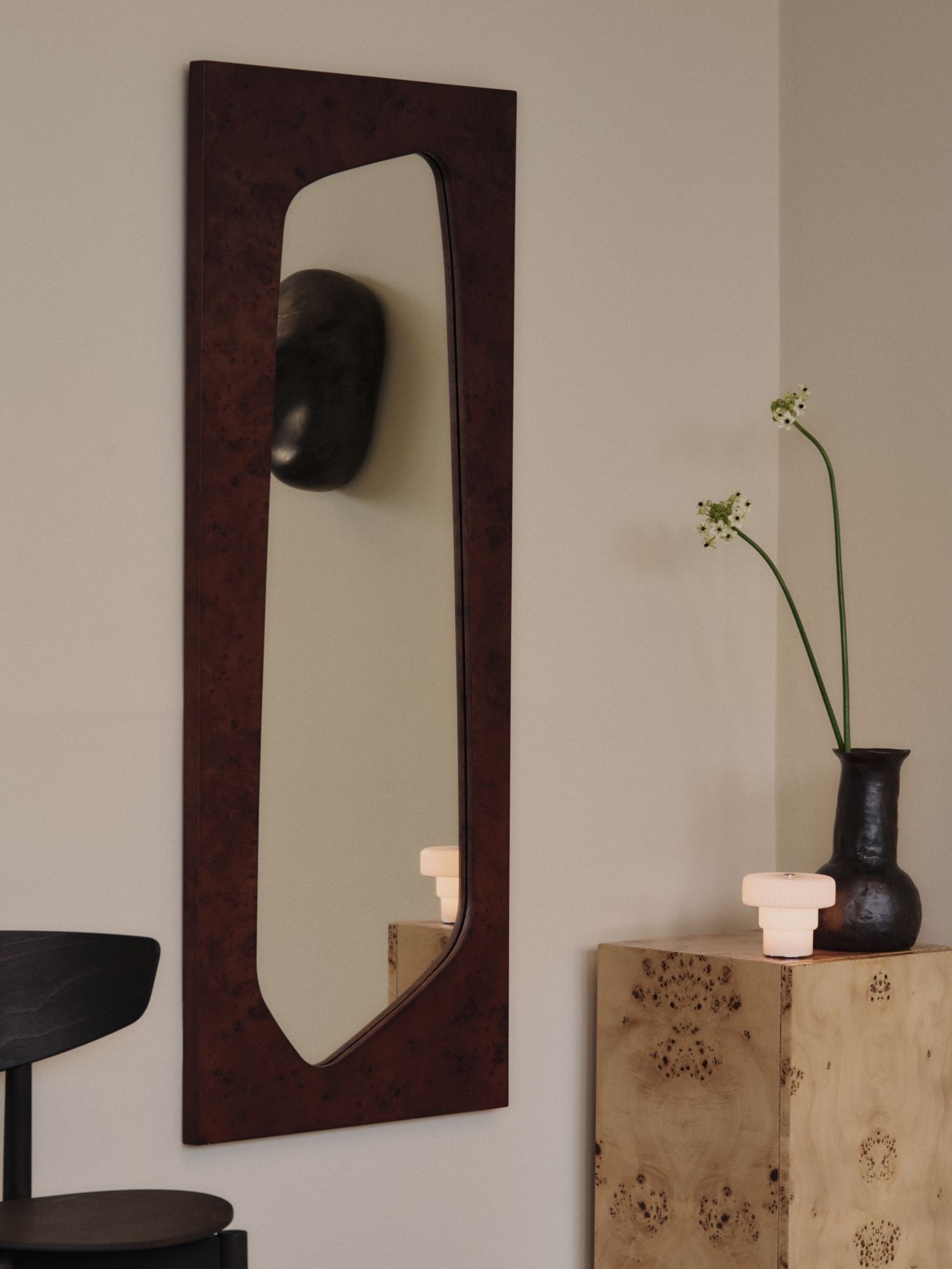 Nahaufnahme der Ripple tragbaren Tischleuchte von Ferm Living auf einem Nachttisch neben einer Vase.