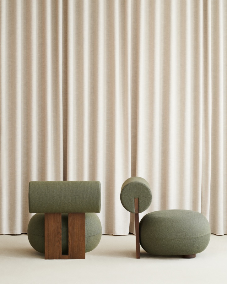 Grüner Hippo Lounge Chair Sessel von NORR11 mit passendem Hocker vor beigen Vorhängen.