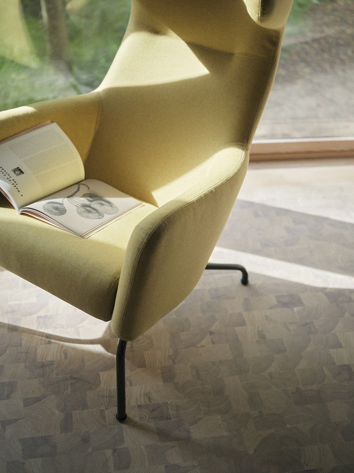 Nahaufnahme des Havana Armchair Ohrensessels Softline in Gelb mit Buch auf der Sitzfläche.