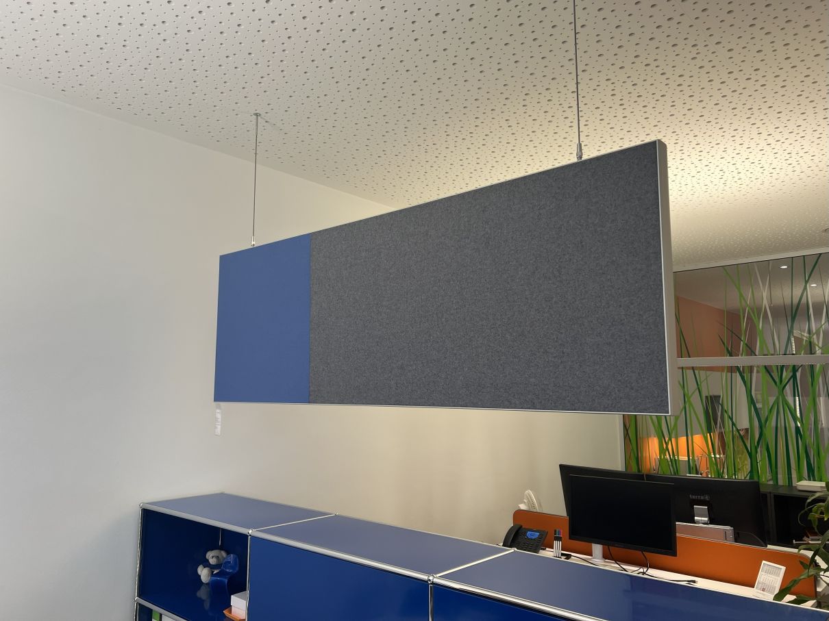 AOS Akustik Pendelwand in Blau-Grau über einem blauen Büroschrank, hängende Schallabsorption für bessere Raumakustik.