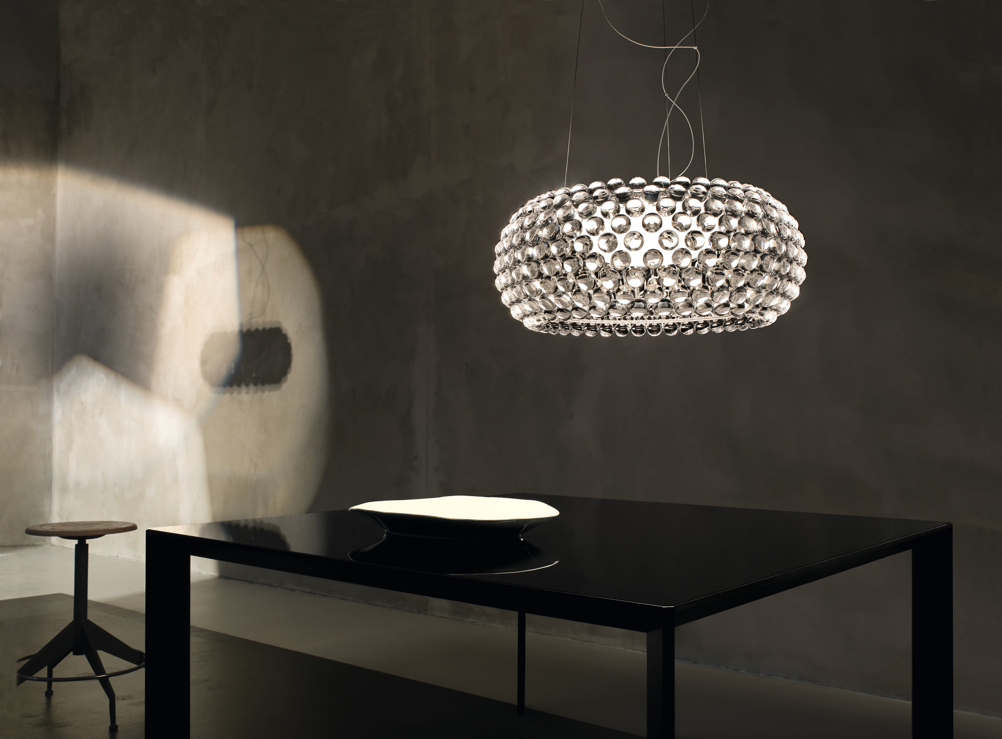 Caboche Pendelleuchte von Foscarini, moderne Designerlampe mit transparenten Kugeln über einem Esstisch.
