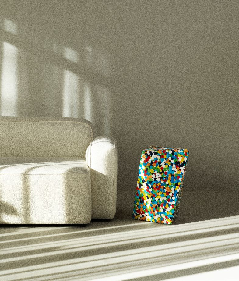 Delta Proust Beistelltisch von Normann Copenhagen, bunter Akzenttisch neben einem beigen Sofa im sonnigen Wohnzimmer.
