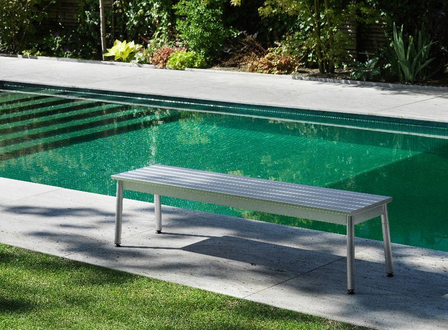 Ex Bank Outdoor von Normann Copenhagen, moderne Gartenbank aus Aluminium neben einem Pool.