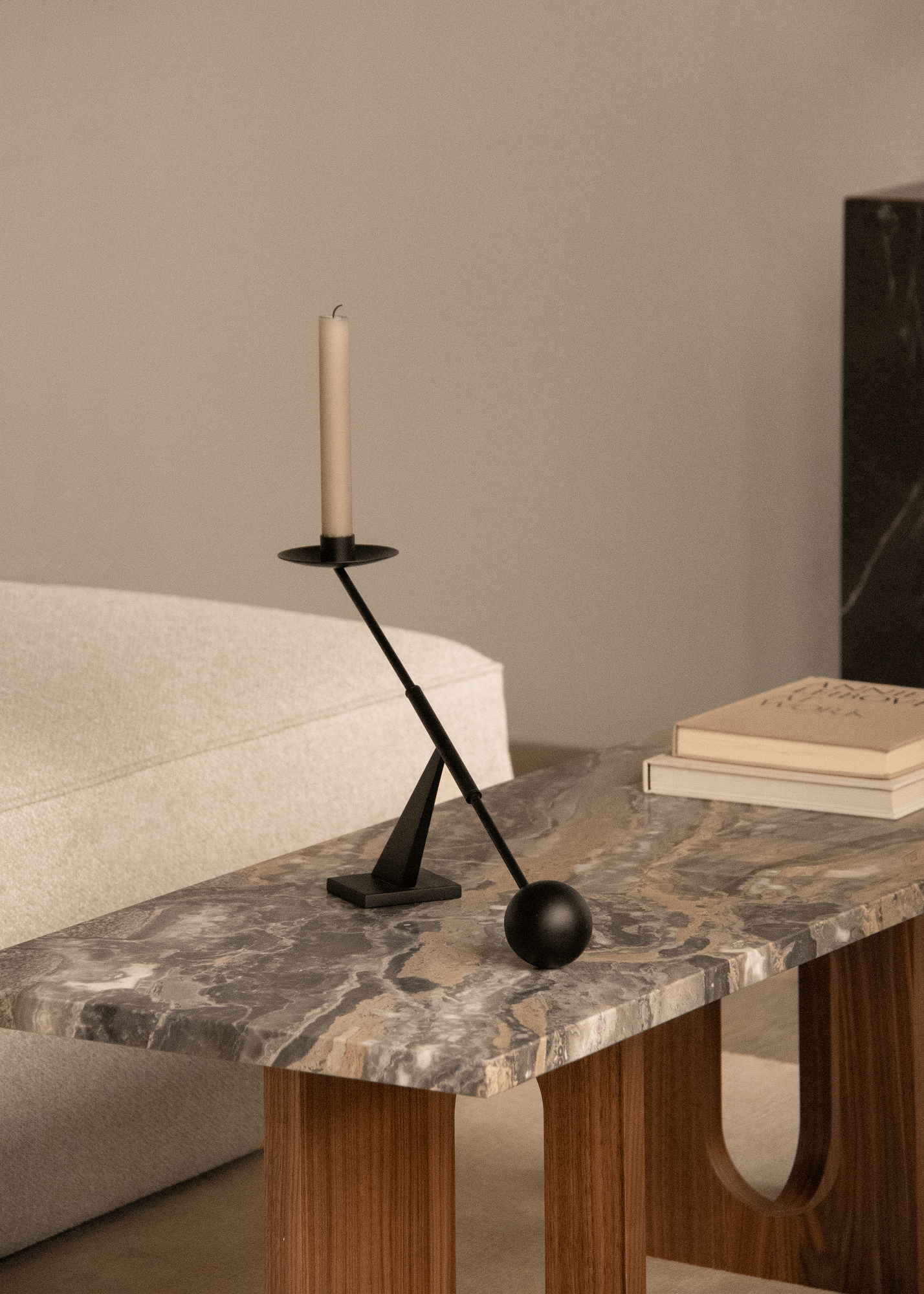 Androgyne Couchtisch von Audo Copenhagen mit Marmorplatte, Kerzenständer und Büchern im modernen Wohnzimmer.