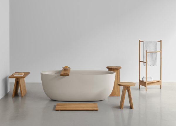 Helle Badewanne mit Holzablage, Bank EK03, Hocker und Handtuchständer aus Holz im minimalistischen Badezimmer.