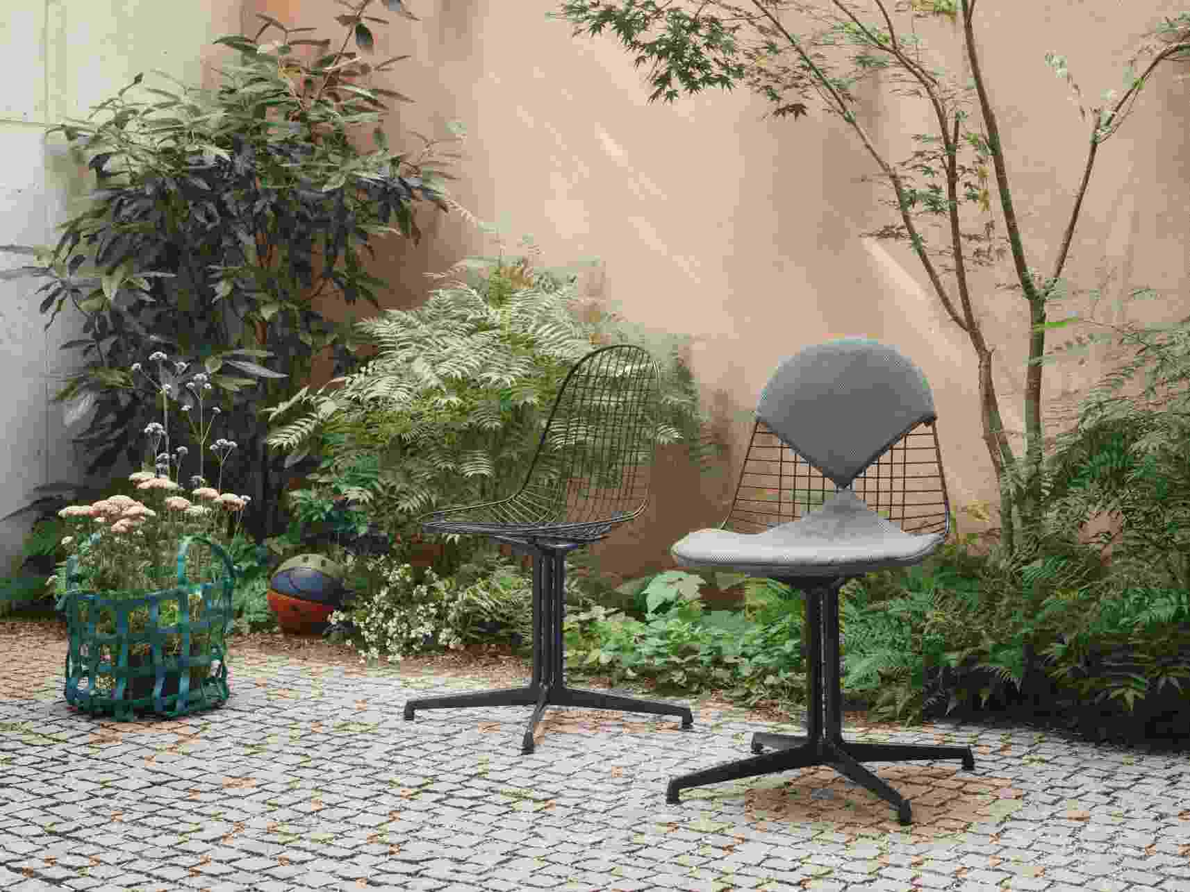 Zwei Vitra Wire Chairs Bikini Outdoor in einer grünen Gartenumgebung, moderne Gartenmöbel.