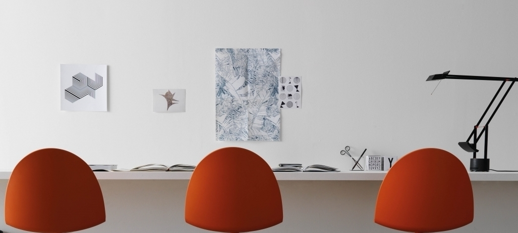 Camel Chair Segis orange Drei orangefarbene Camel Stühle von Segis stehen an einem Schreibtisch in einem minimalistischen Büro.