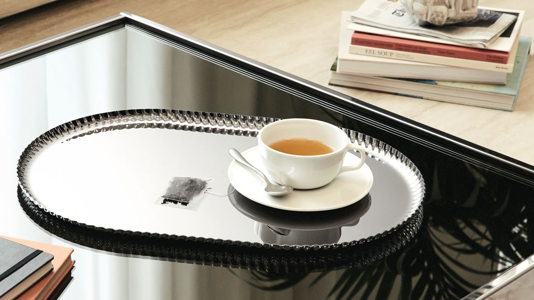 JK01/46B Pleats Tablett von Alessi mit Teetasse und Teelöffel auf einem Couchtisch.
