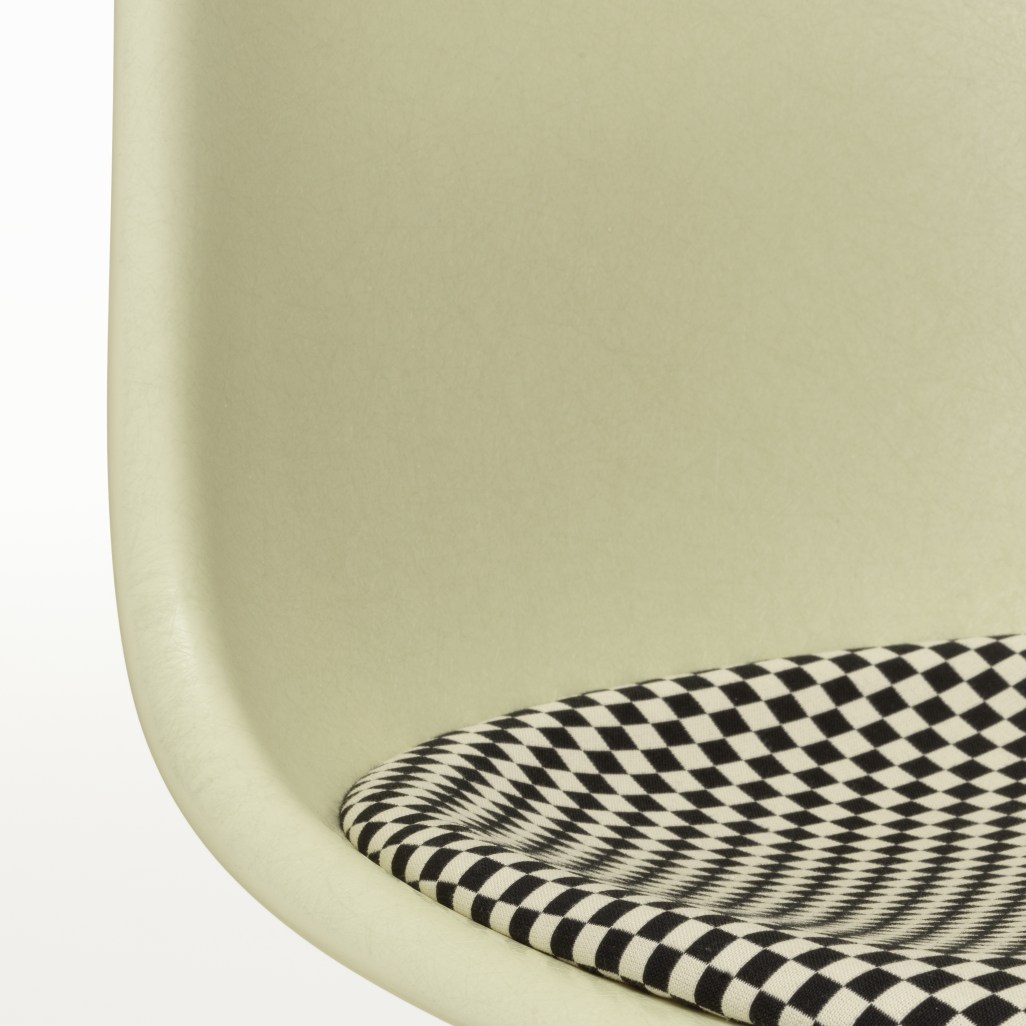 Detailaufnahme von Vitra Eames Fiberglass Side Chair DSL in Hellgelb mit Schachbrettmuster-Sitzpolster.