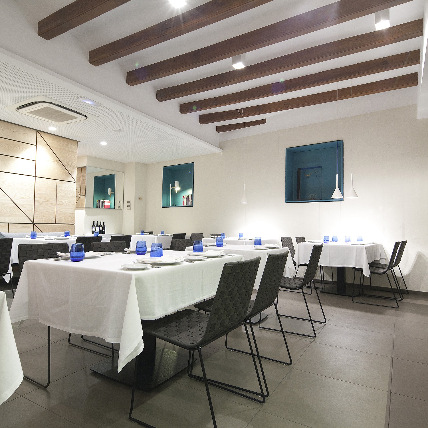 Innenaufnahme eines Restaurants mit Tischen und Andreu World Trenza SI0700 stapelbaren Outdoor Stühlen.