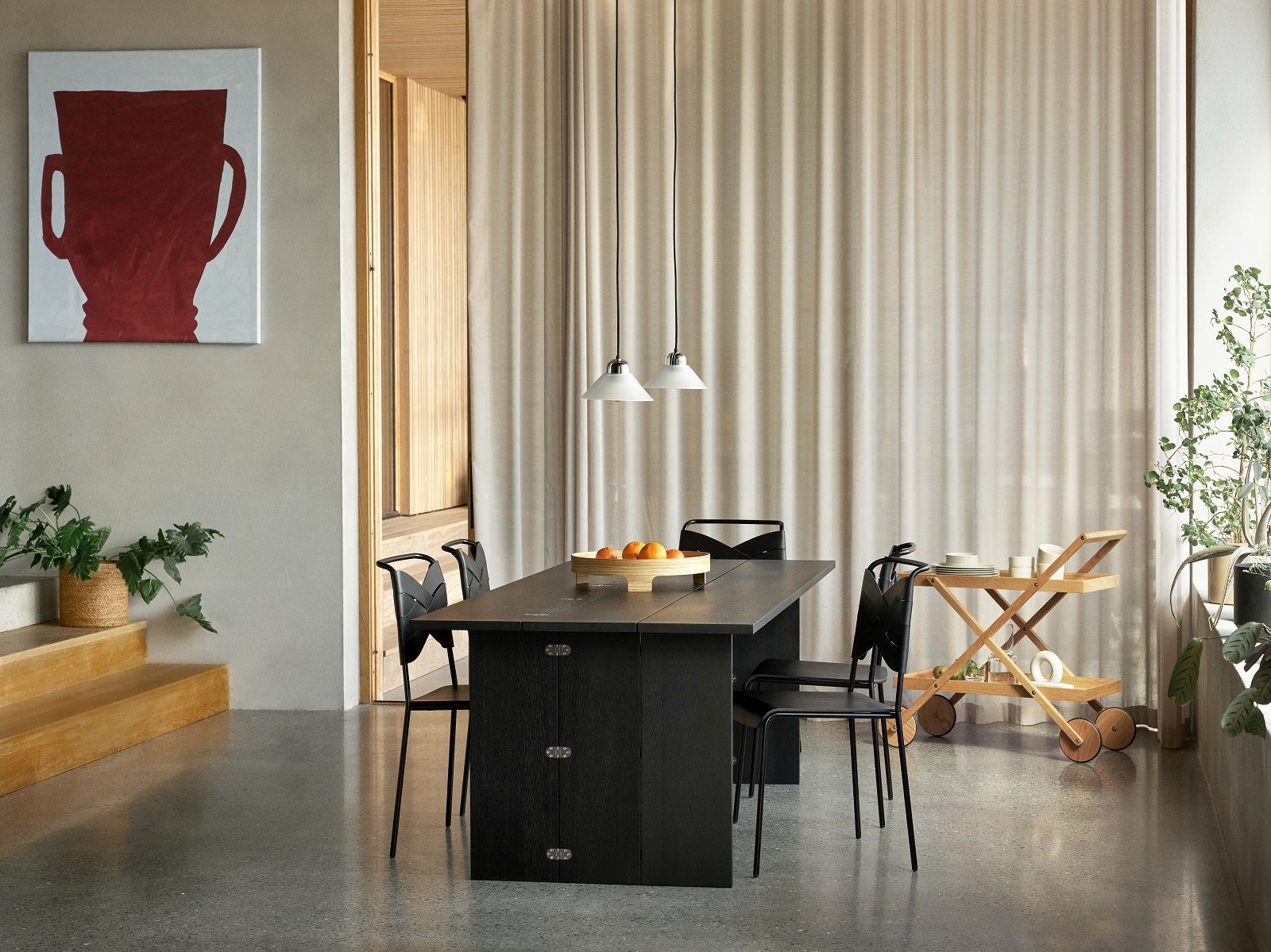 Esszimmer mit Esstisch, Stühlen und zwei Kalo Lamp Pendelleuchten von Design House Stockholm über dem Tisch.