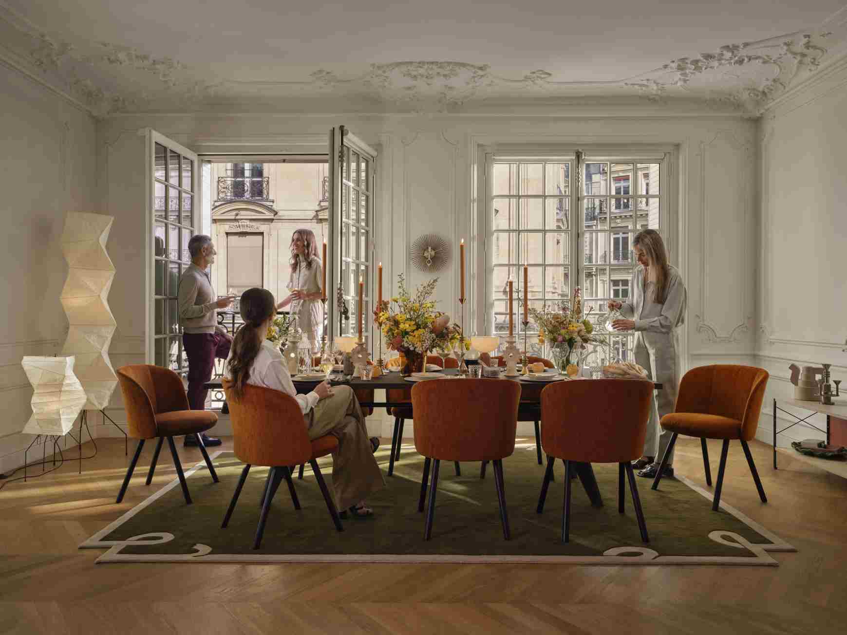 Wohnzimmer mit Esstisch und Vitra Popsicle Clock Wanduhr über dem Tisch an der Wand.