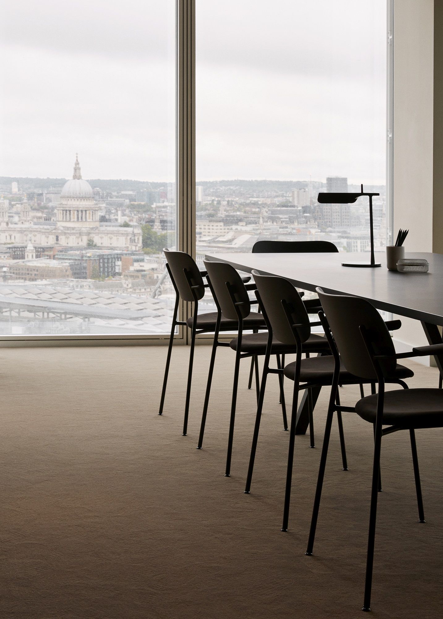 Reihe schwarzer Co Dining Chair Stühle von Audo Copenhagen an einem Konferenztisch mit Blick auf London.