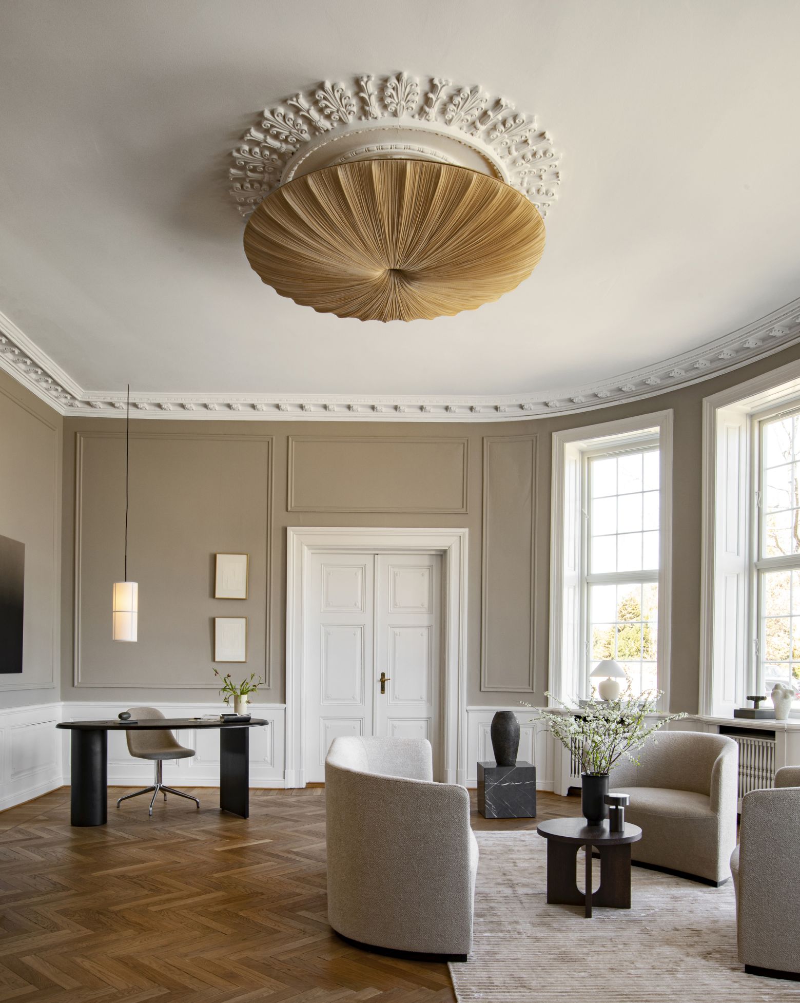 Wohnzimmer Interieur mit Androgyne Beistelltisch von Audo, Design Möbel, Sessel, Tisch und dekorativer Deckenleuchte.