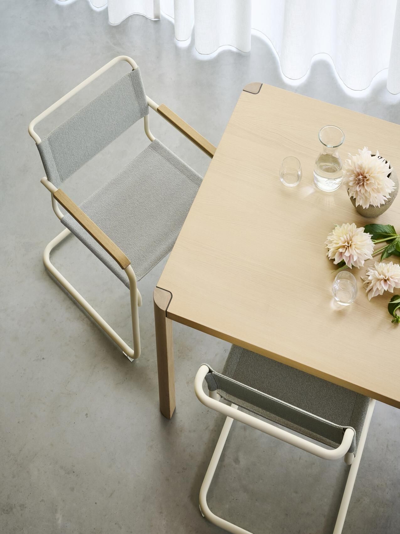 S 34 V Thonet Freischwinger Stuhl in Grau mit Armlehnen und Holztisch mit Blumendekoration, Top-Ansicht.