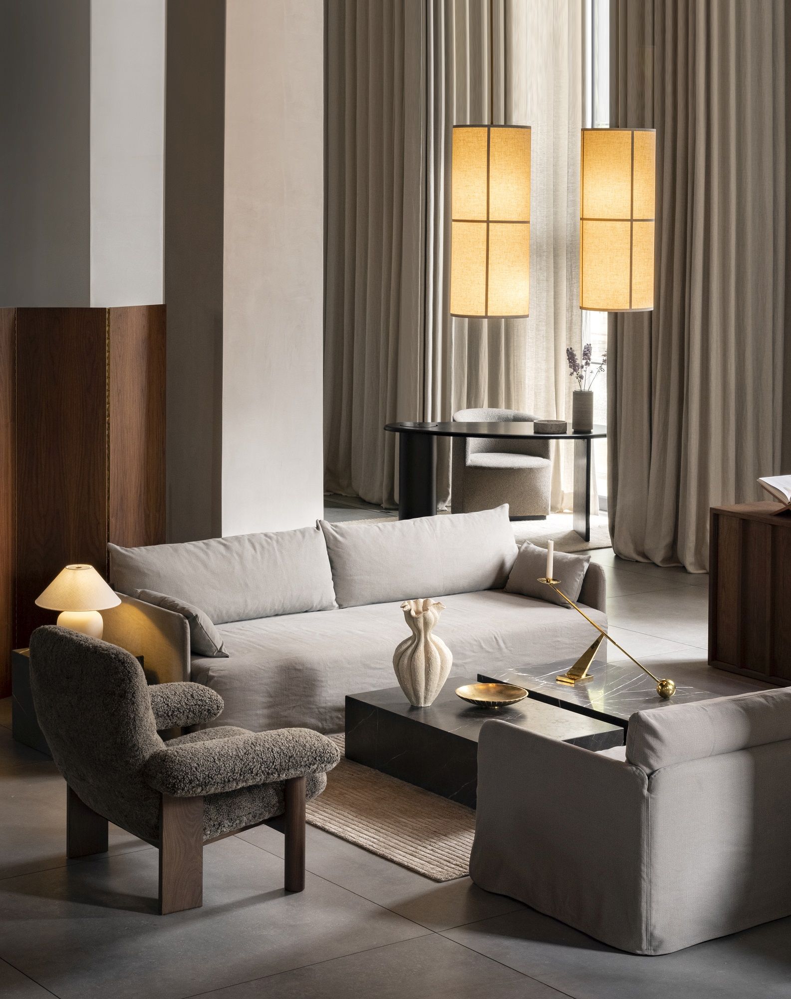 Wohnzimmer Interieur mit Audo Copenhagen Tearoom Club Chair Sessel aus Bouclé und Sofa in Leinenoptik.