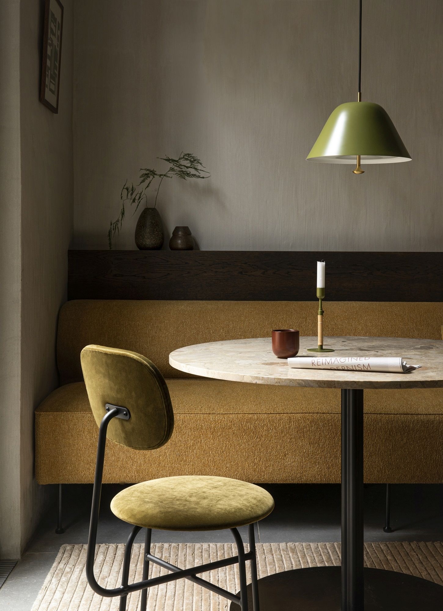 Audo Copenhagen Afteroom Stuhl in Olivgrün am Esstisch mit Bank und Pendelleuchte.