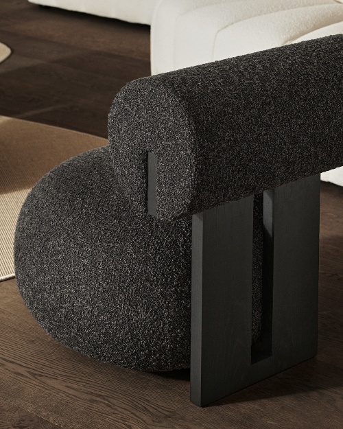 Detailaufnahme des Hippo Lounge Sessel NORR11 mit dunklem Bouclé-Stoff und schwarzen Holzbeinen.