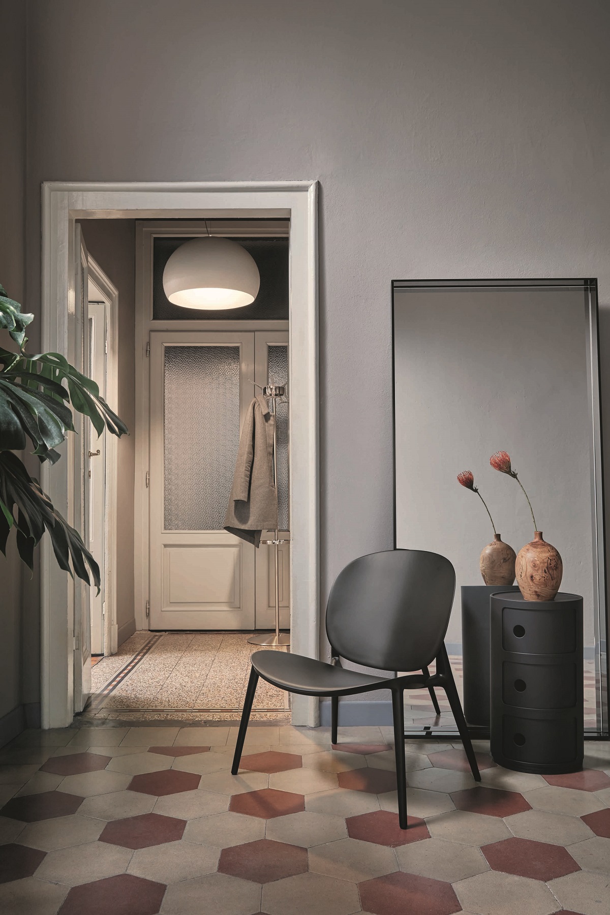 Grauer Componibili Container mit drei Elementen von Kartell im stilvollen Interieur mit Stuhl und Spiegel.