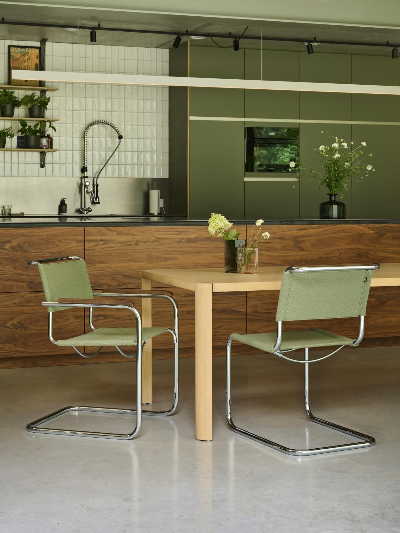 Zwei Thonet S 33 Freischwinger Stühle in Grün an einem Esstisch in moderner Küche.