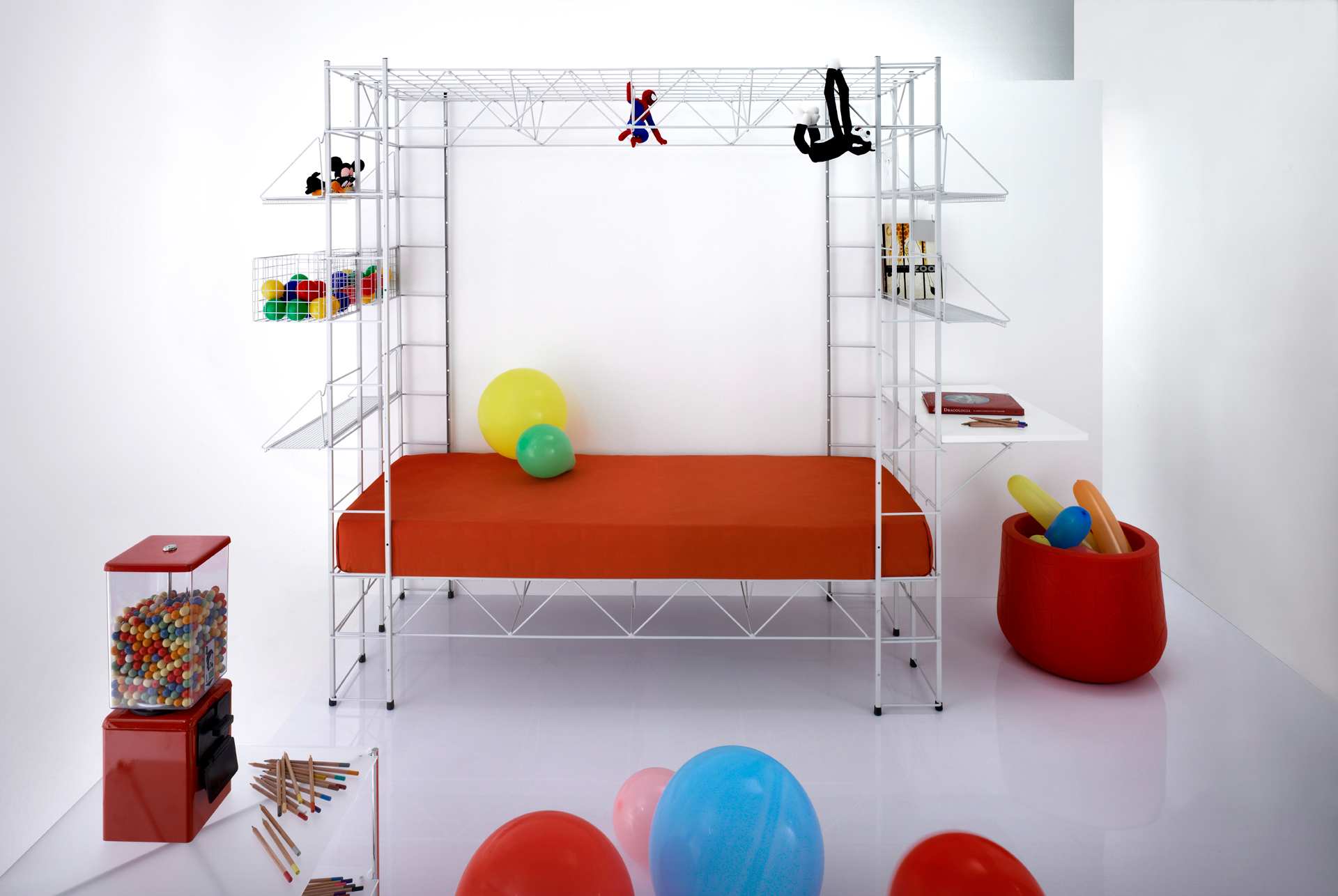 Abitacolo Multifunktionsbett von Rexite mit weißem Metallgestell, orangefarbener Matratze und bunten Spielsachen im Kinderzimmer.