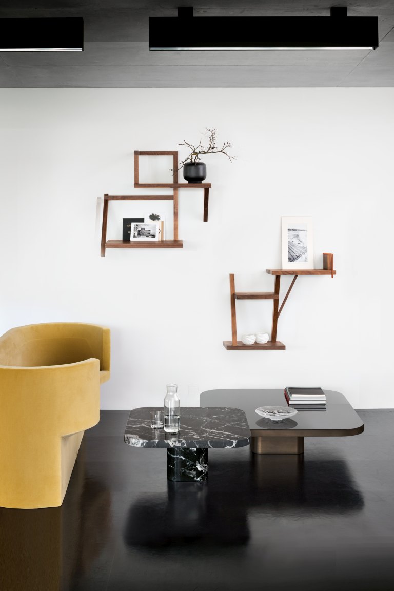 Bow Coffee Table von ClassiCon: Moderner Couchtisch mit Marmorplatte und schwarzem Glas, kombiniert mit stilvollen Wandregalen.