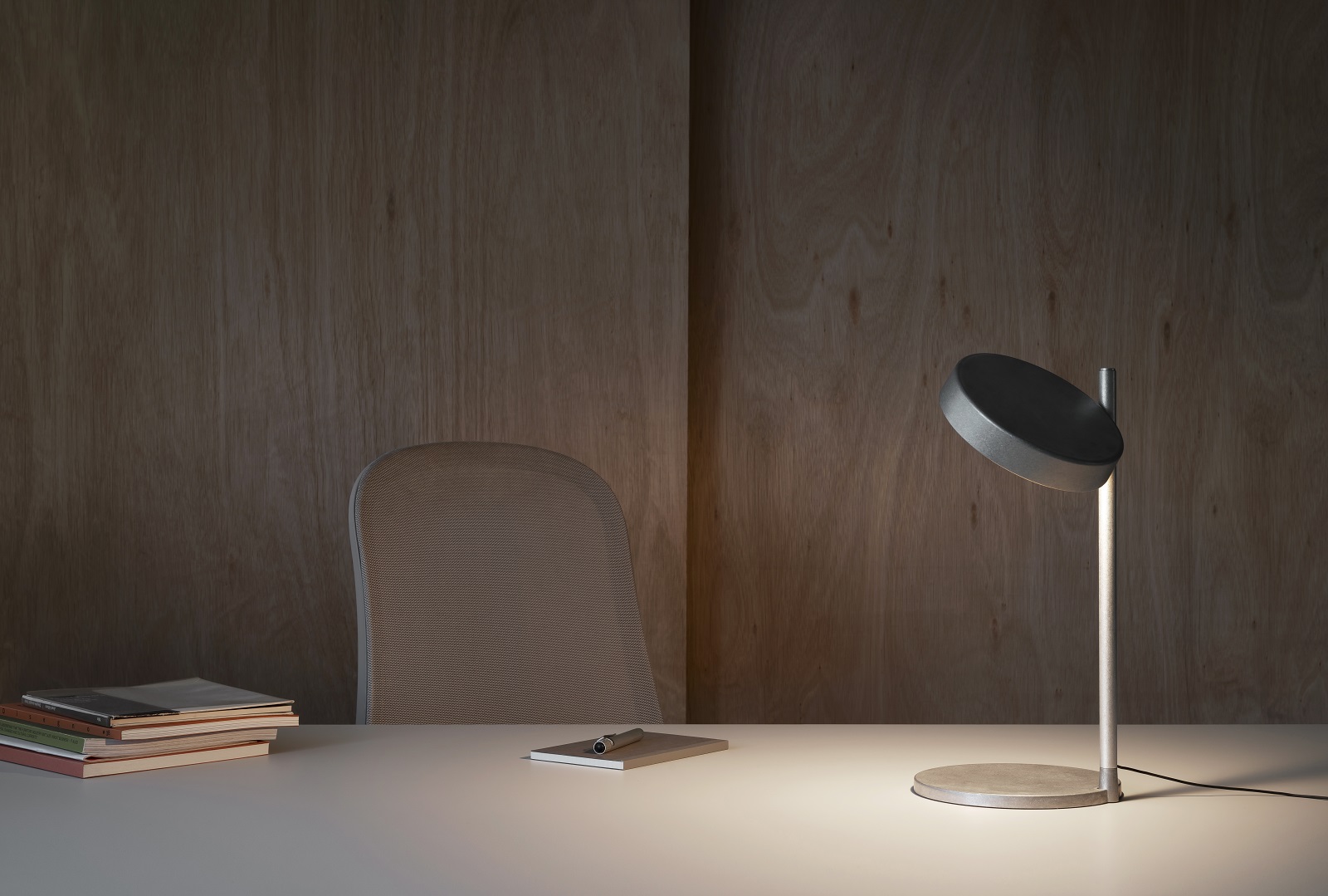 w242 B2 Tischleuchte von wästberg aus Aluminium auf einem Schreibtisch mit Büchern und Stuhl.