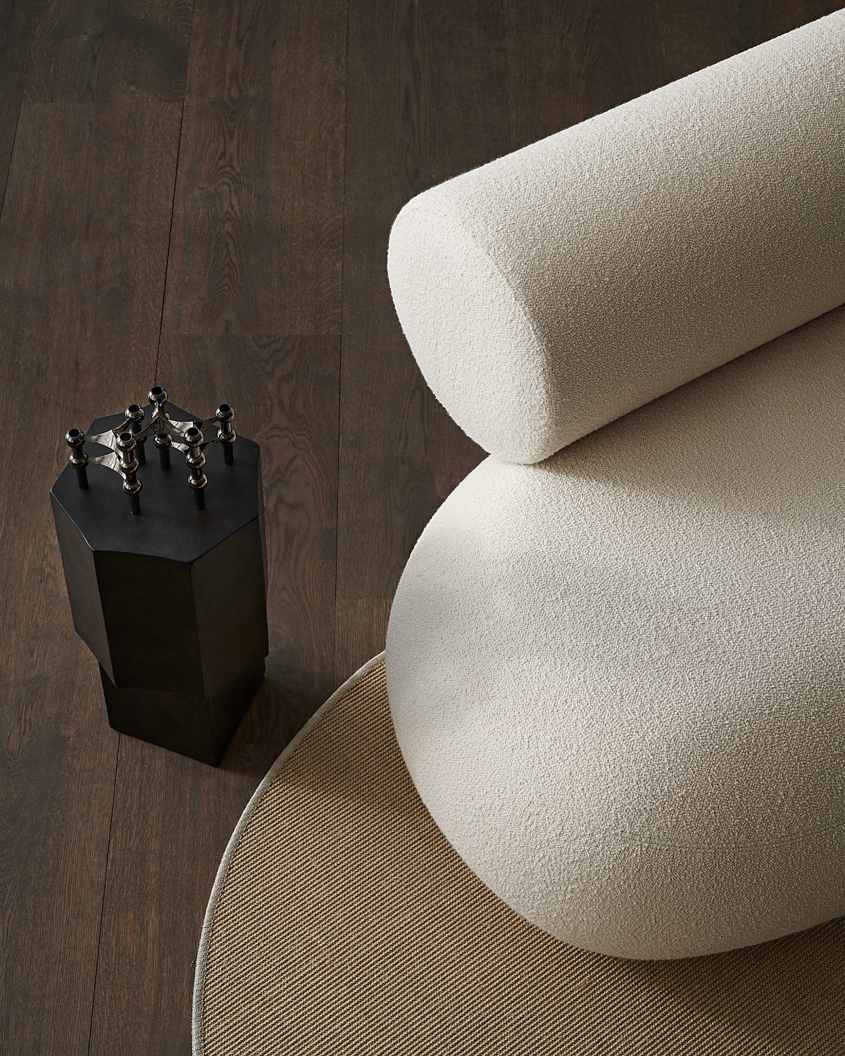 Detailaufnahme des Hippo Sofa Holz Norr11 mit cremefarbenem Bouclé-Bezug, abgerundeten Formen und dunklem Holzboden.