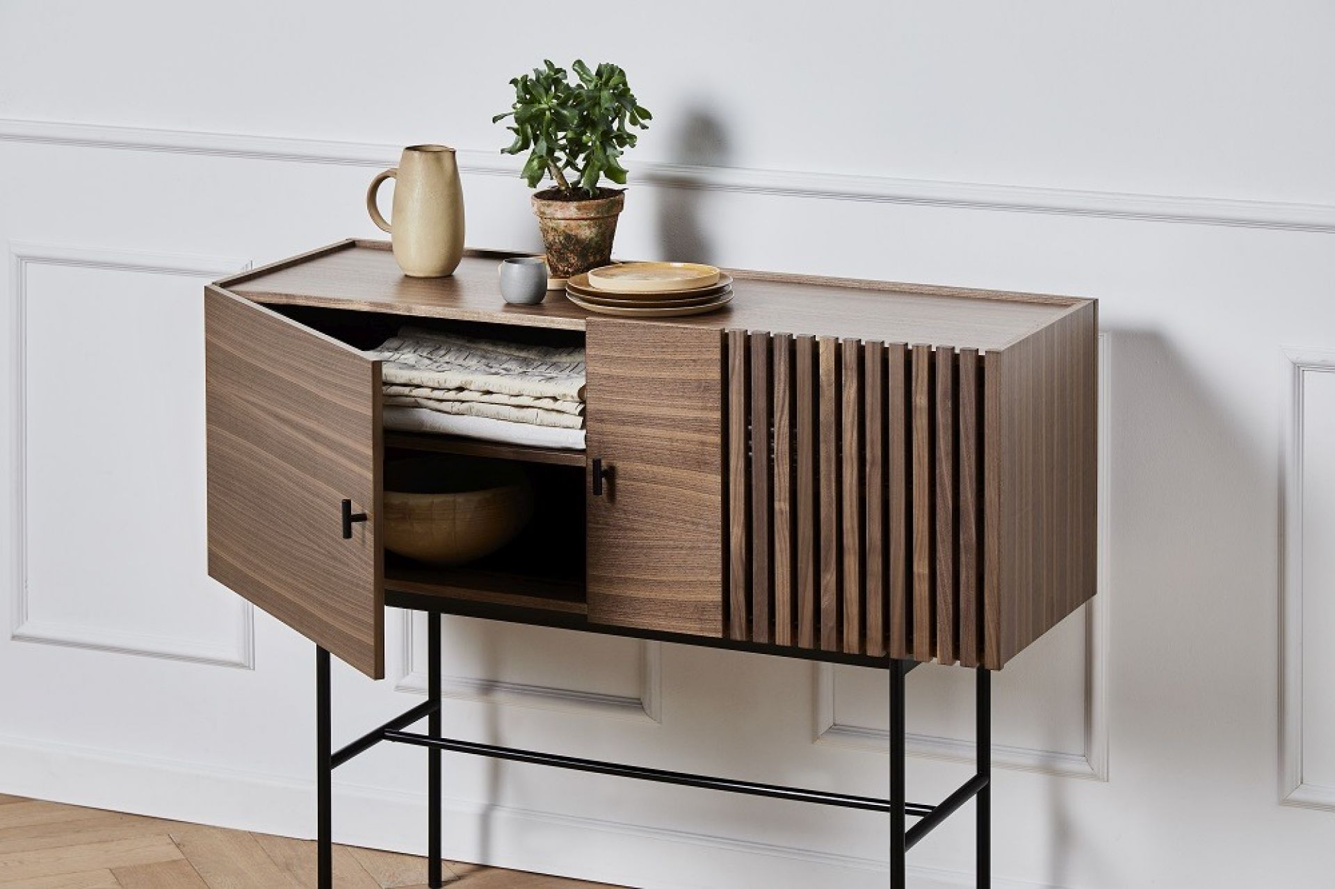 Array Sideboard aus Walnuss-Holz von Woud mit geöffneter Tür und Gegenständen darauf.
