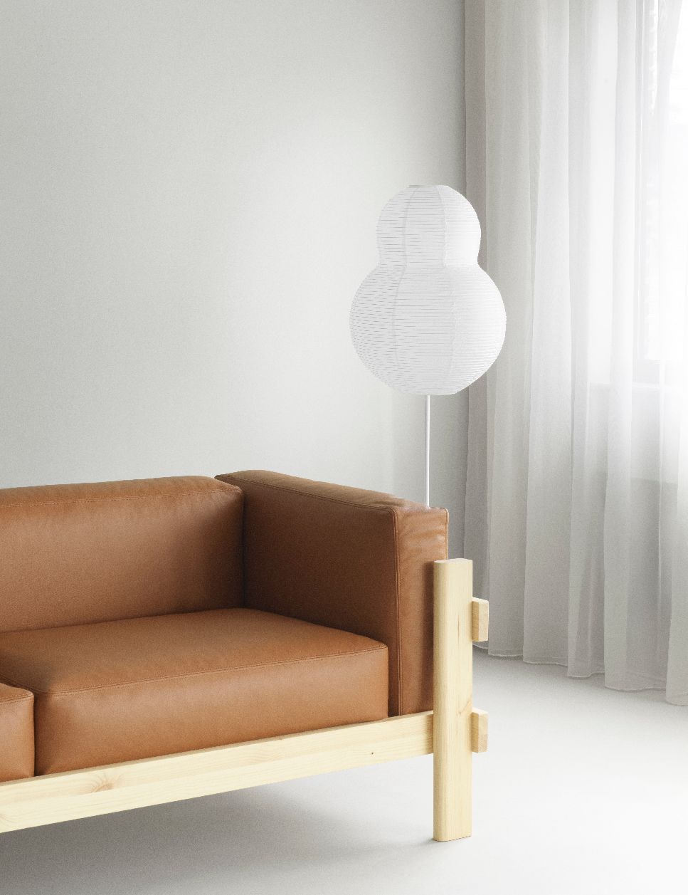 Nahaufnahme des Normann Copenhagen Kube Sofas mit braunem Lederbezug und hellem Holzrahmen, minimalistisches Design.
