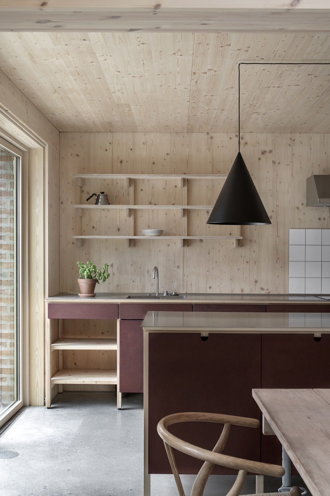 Moderne Küche mit w221 S2 Medium Pendelleuchte von wästberg in Schwarz über einer Kücheninsel.