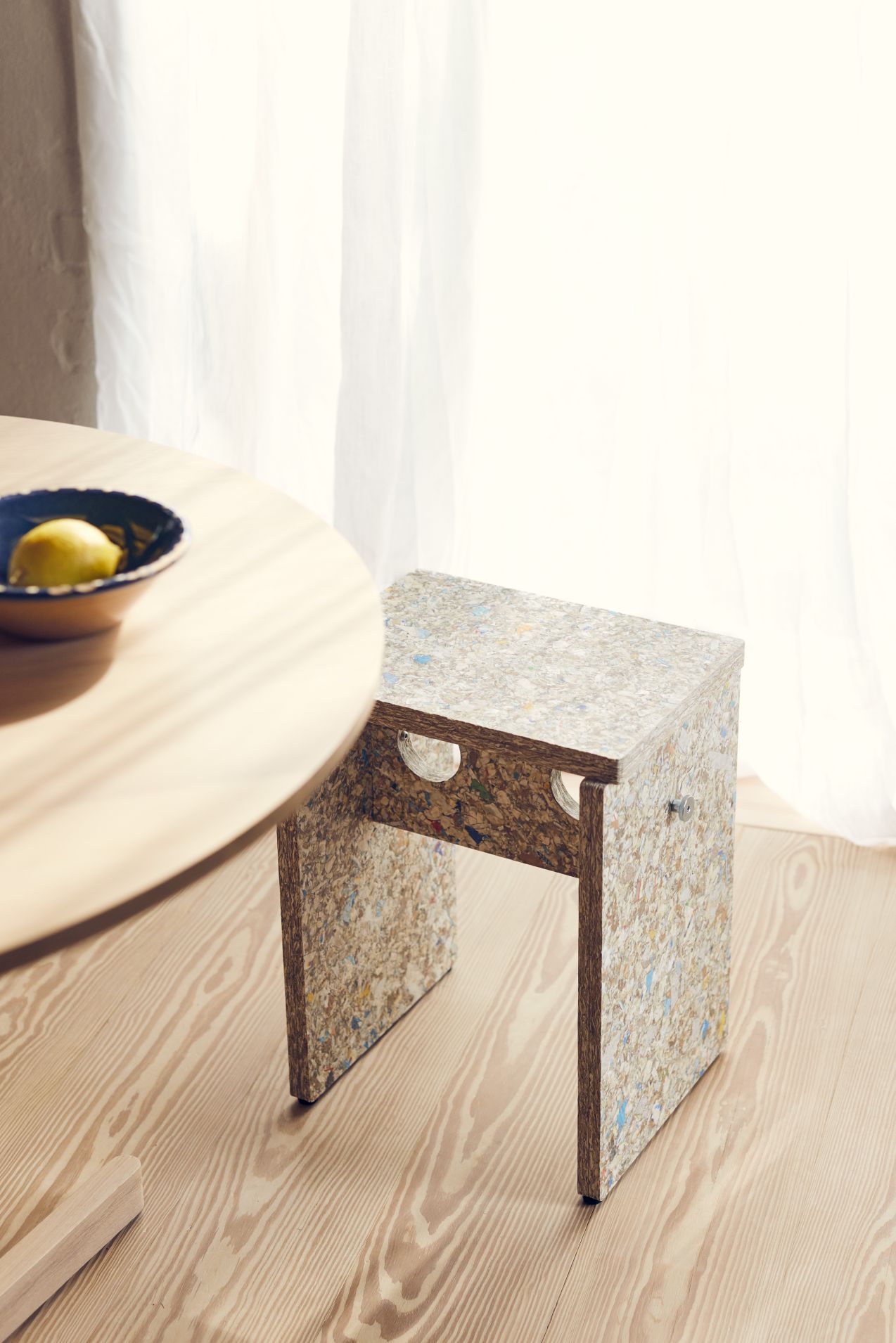 Remake Hocker Form & Refine aus recyceltem Kunststoff neben einem Holztisch mit Zitrone.