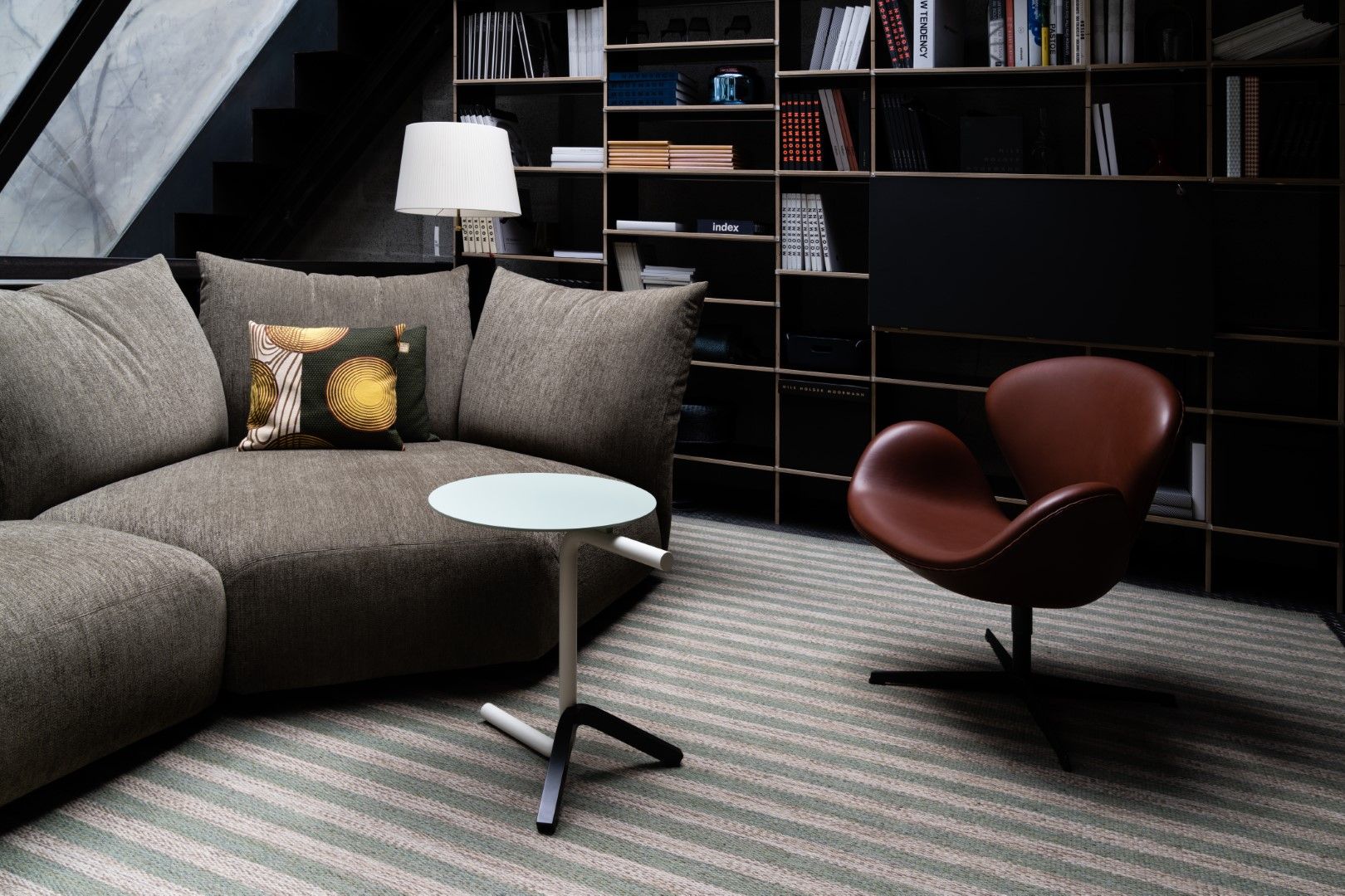 Aso Beistelltisch Mox in modernem Wohnzimmer mit Sofa, Sessel und Bücherregal.