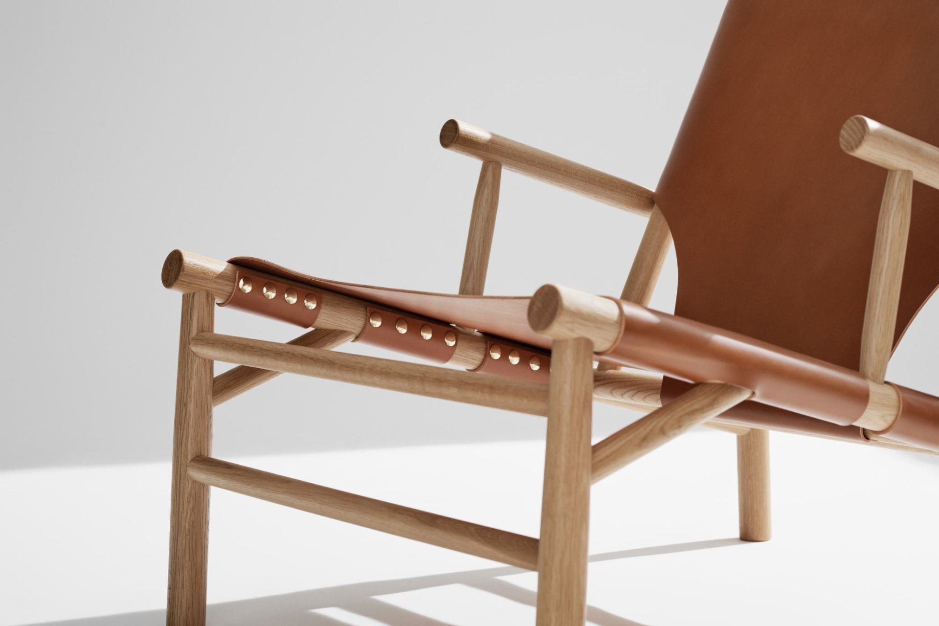 Samurai Lounge Chair Sessel von NORR11, Detailaufnahme mit hellem Holzrahmen und braunem Lederbezug mit goldenen Akzenten.