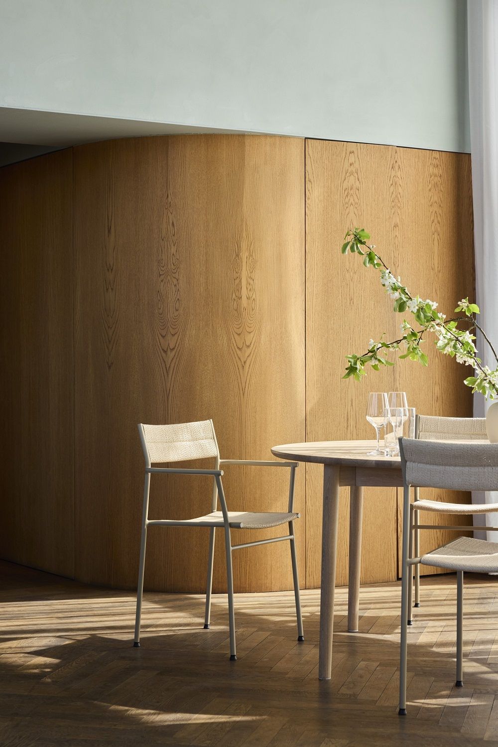 Vev Dining Armlehnstuhl von Northern an Esstisch mit Gläsern, stilvolles Esszimmer-Interieur.