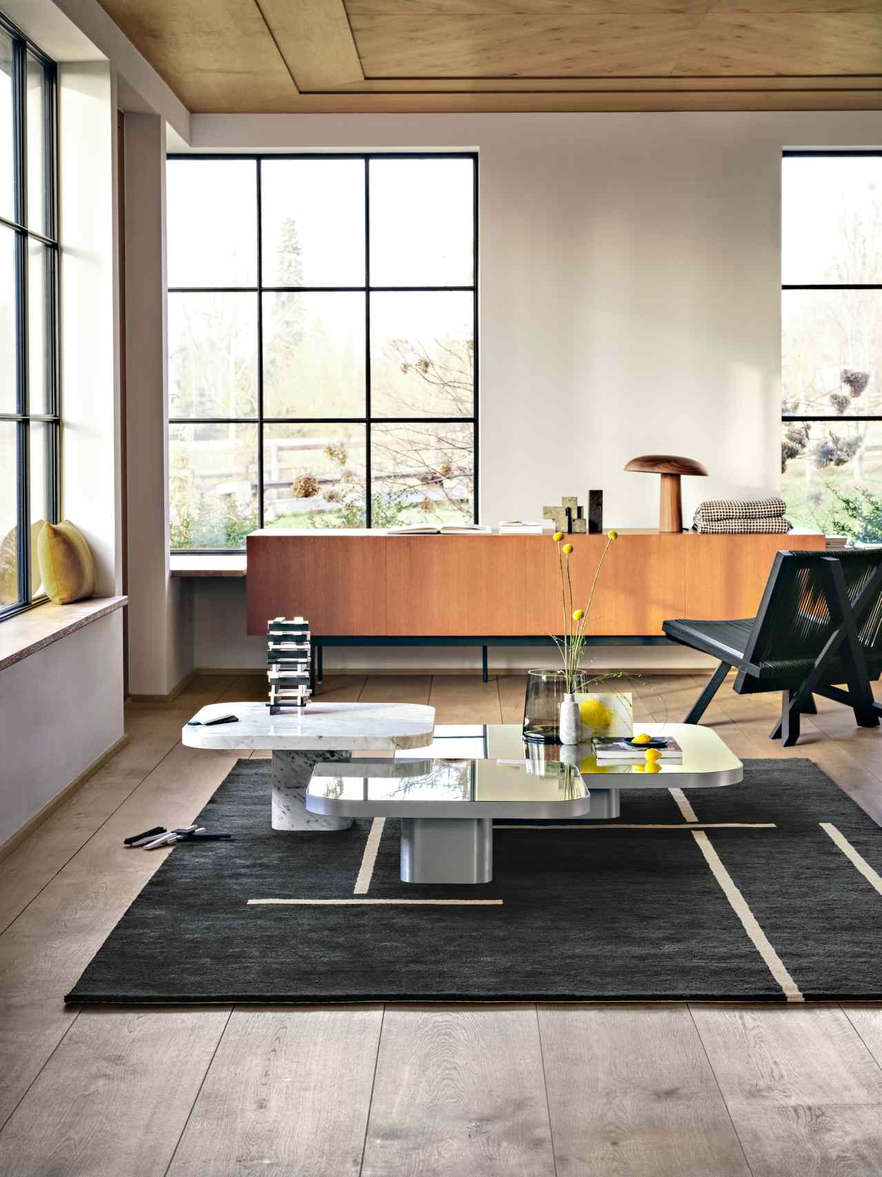 Heller Wohnraum mit ClassiCon Bow Coffee Table, Design Couchtisch mit Marmor und Glasplatten.